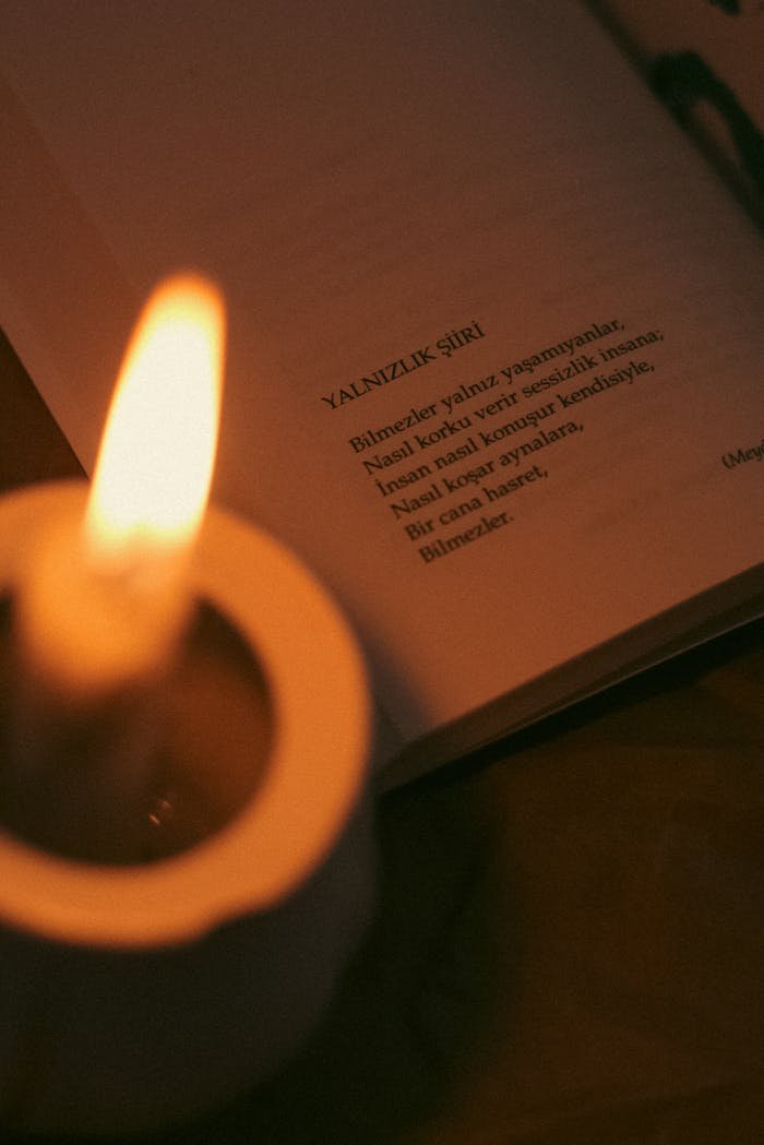 testimonial-img Close-up of a candle illuminating a book page with Turkish poetry, creating a cozy atmosphere.