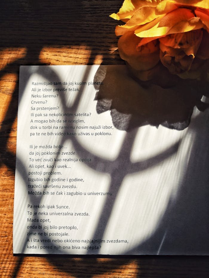 service-03 A page of poetry with artistic shadows next to vibrant yellow flowers.